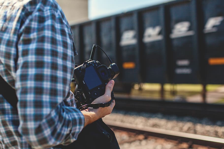 person holding DSLR camera near cargo container during daytime, HD wallpaper