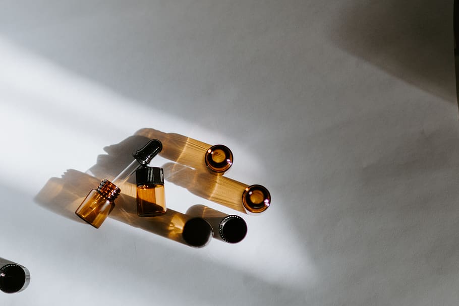 brown glass bottles, smoke pipe, amber, sun, hand, oils, essential oil HD wallpaper