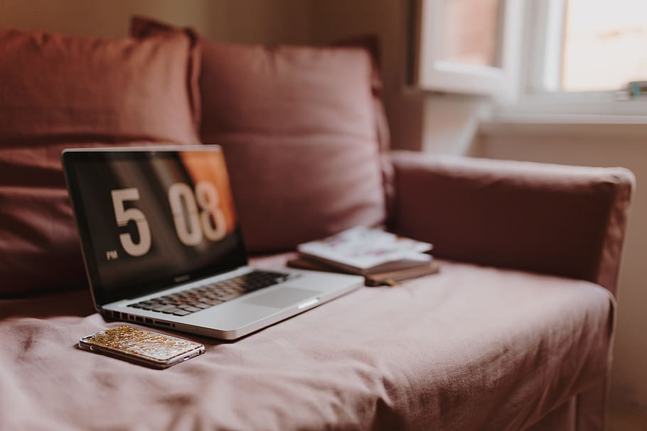 Workplace with a laptop on a pink couch, macbook, macbook pro HD wallpaper