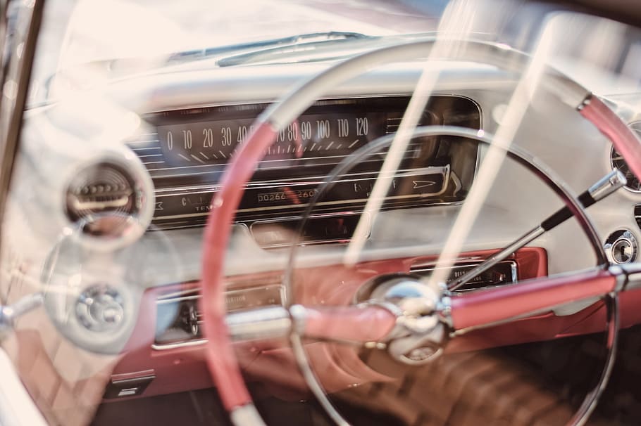 The steering wheel and dashboard inside an older car., car backgrounds