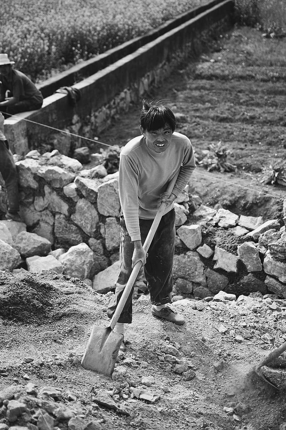 grayscale photo of man holding shovel, tool, human, person, rubble