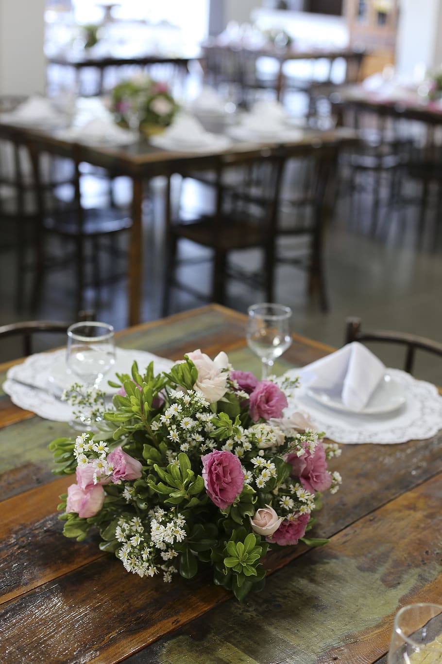 Pink And White Flower Centerpiece Beside Wine Glasses And Plates On Brown Table HD wallpaper