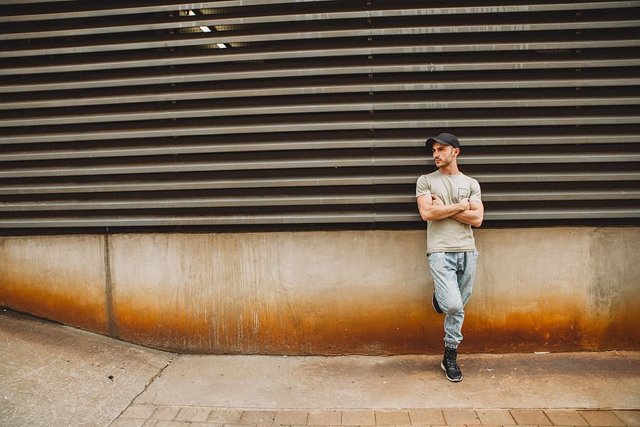 man leaning on wall during daytime, person, human, clothing, apparel