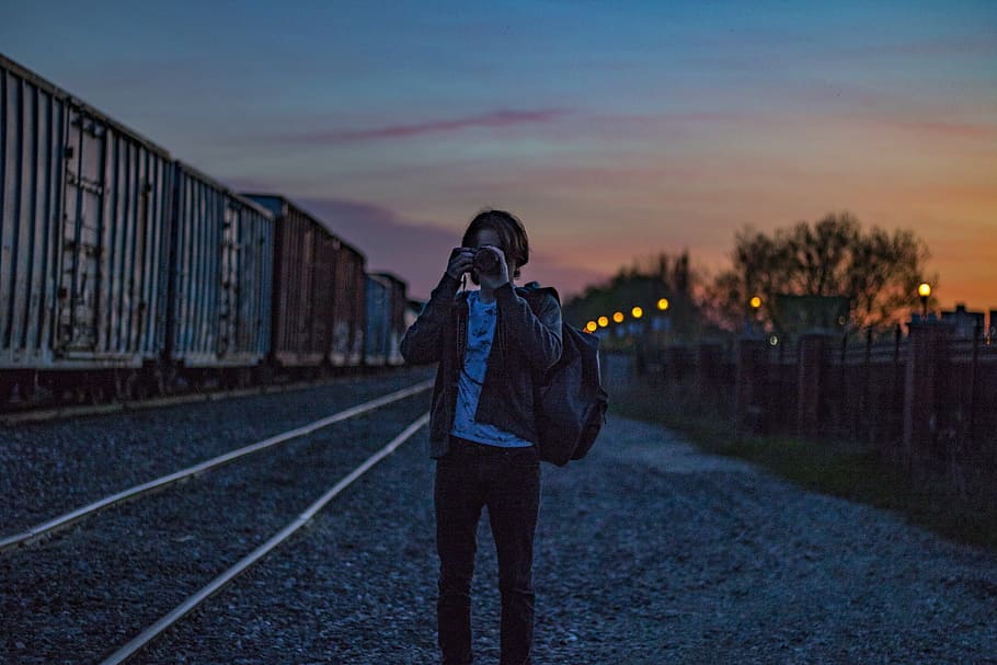 Man Wearing Brown Jacket With Backpack Taking Photo during Golden Hour HD wallpaper
