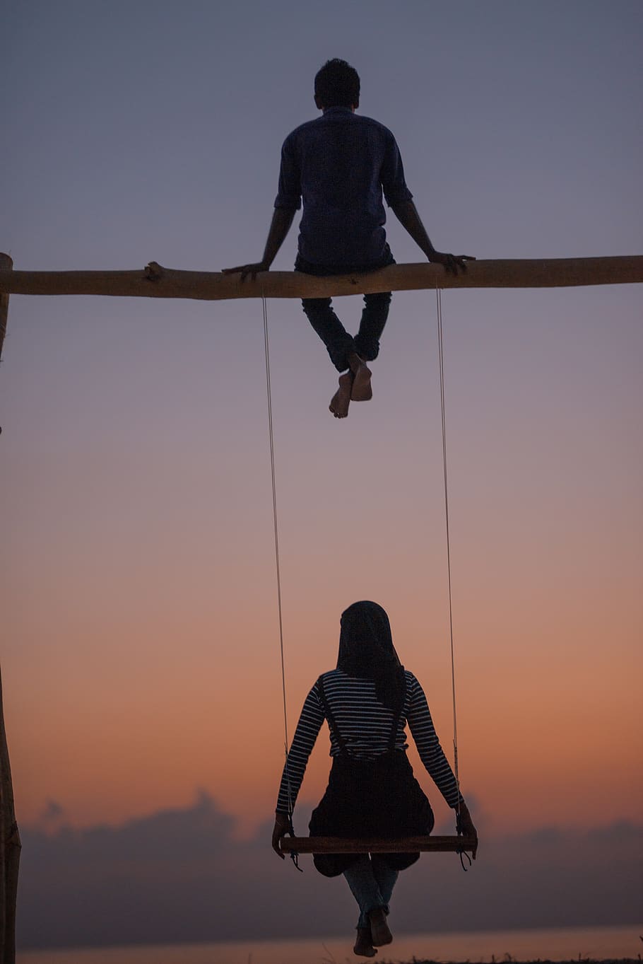 woman sitting on swing under man, person, human, silhouette, leisure activities