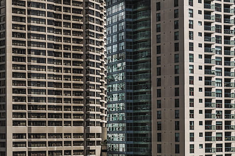Looking at rows of windows on a highrise buildings exterior from the ground HD wallpaper