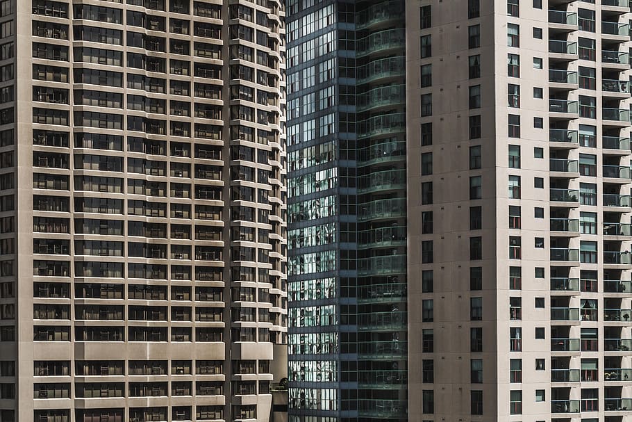 Looking at rows of windows on a highrise buildings exterior from the ground HD wallpaper