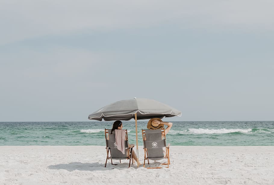 two people under beach umbrella near shoreline, sand, sky, horizon HD wallpaper