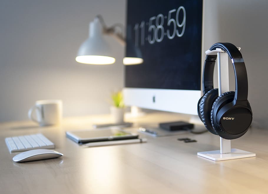 black Sony headphones beside iMac on top of table, working, desktop