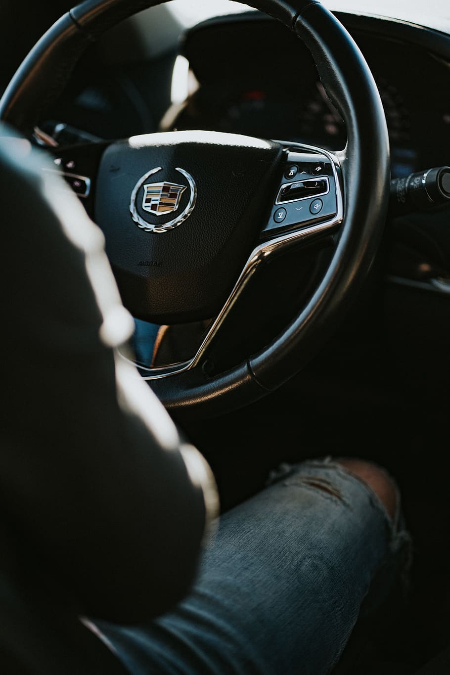 person in blue distressed denim jeans sitting on driver seat inside Cadillac car during daytime, HD wallpaper