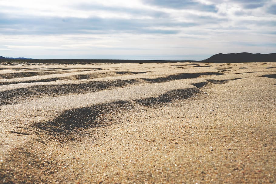 beach, sand, wind, rock, sun, cloud, mountain, water, sea, land HD wallpaper