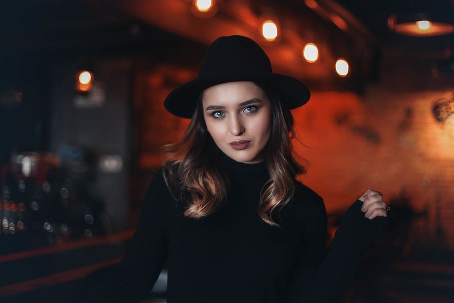 woman in black fitted sweater inside bar, apparel, clothing, hat