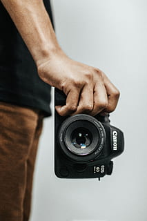 Person Holding Black Canon Eos 6d Dslr Camera, aperture, hand HD wallpaper