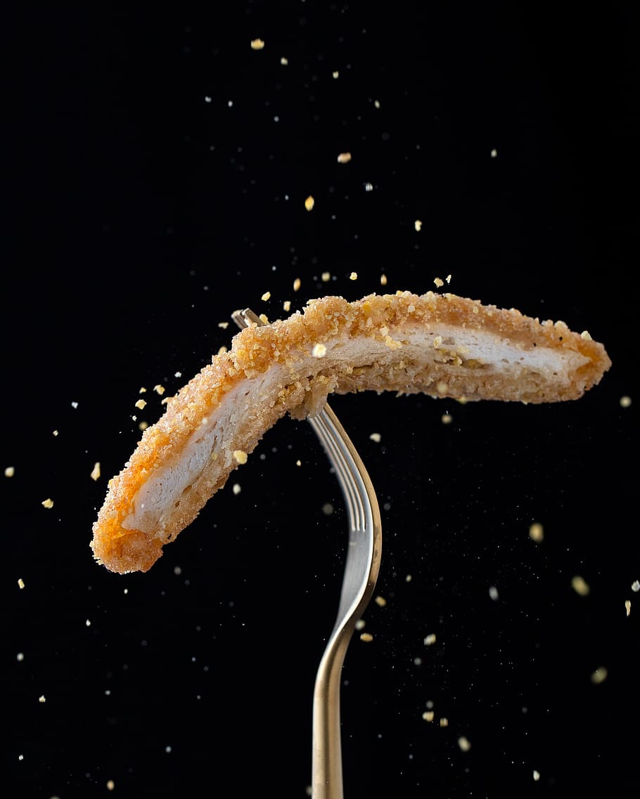 stainless steel fork with sliced breaded meat, black background HD wallpaper