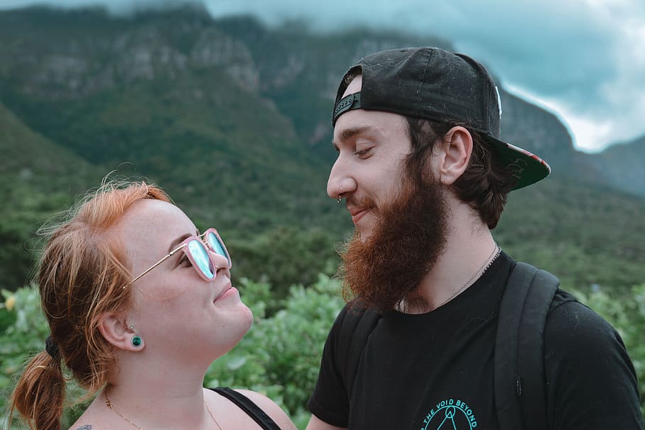 man and woman looking each other while smiling with mountain view HD wallpaper