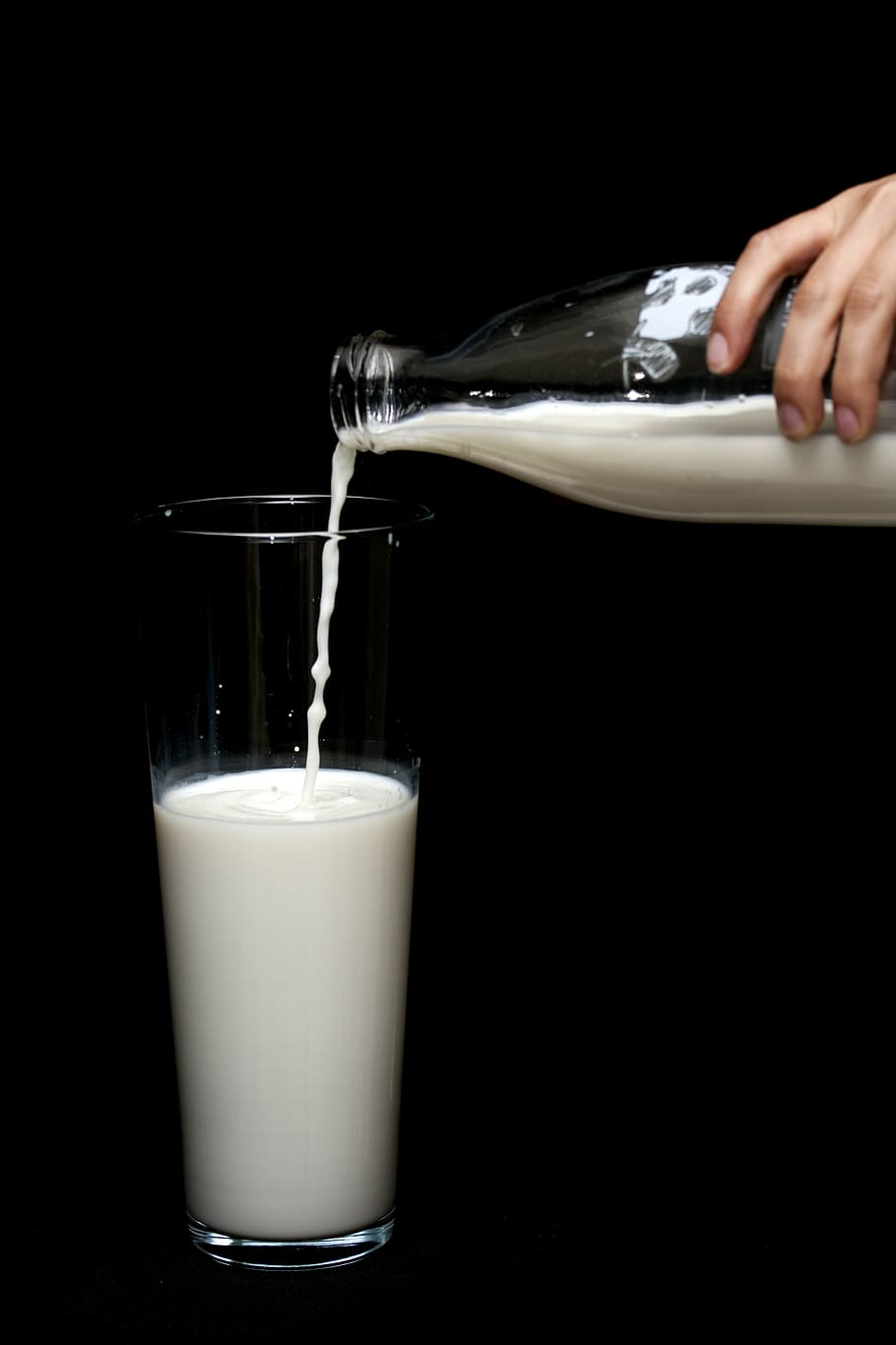 Person Pouring Milk in Highball Glass, beverage, black background, HD wallpaper