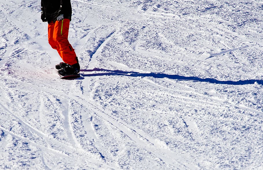 Photo of Person Wearing Black Top and Orange Pants Riding Snowboard HD wallpaper