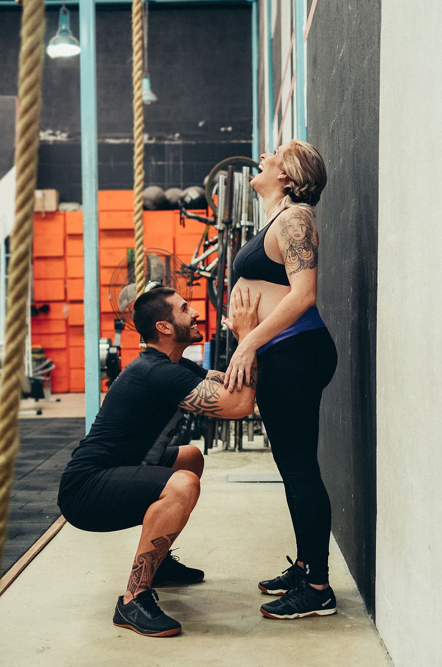 man squatting while touching woman's belly, pregnancy, pregnant woman
