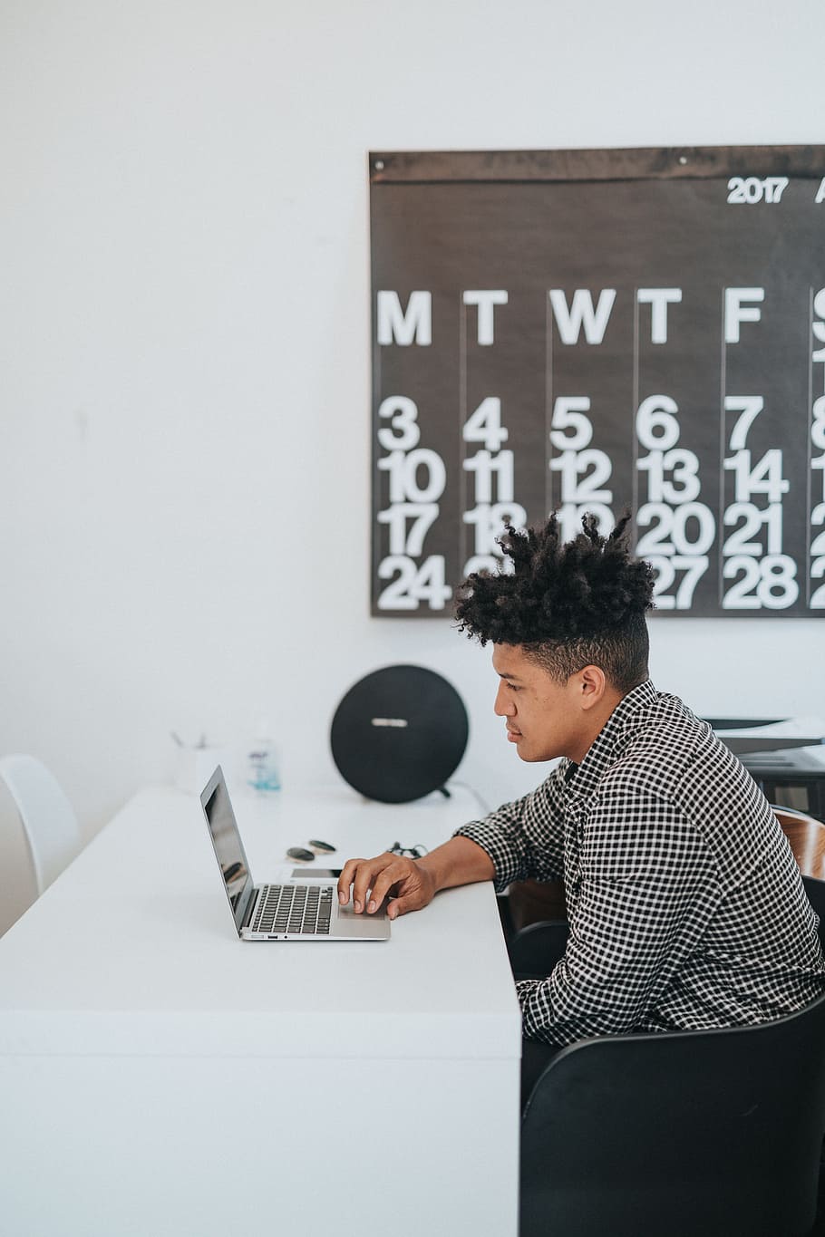 man playing laptop, person, desk, calendar, office, indoor, workstation