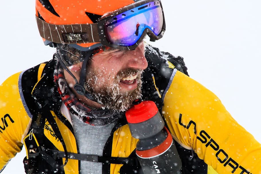 man wearing orange and black snow goggles, apparel, clothing