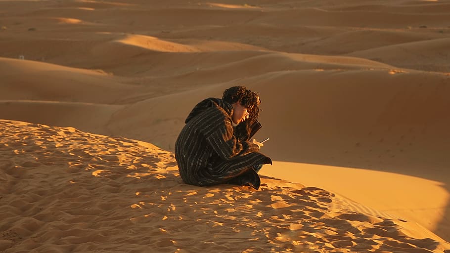 man sitting down on sand, soil, nature, outdoors, desert, dune HD wallpaper