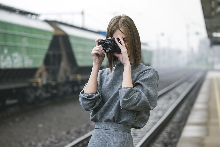 Woman Taking Pictures at Train Station, photography themes, camera - photographic equipment HD wallpaper