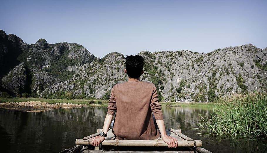 Man Sitting on Bridge Front of Mountain, clouds, daylight, grass HD wallpaper