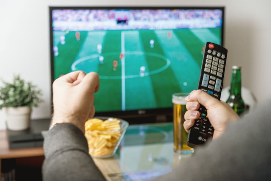 hd-wallpaper-watching-football-match-on-tv-with-remote-controller