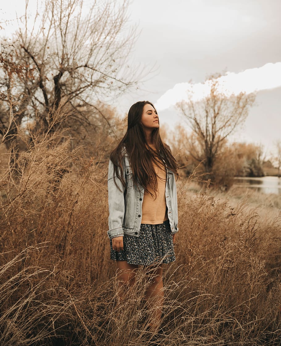 woman in blue denim jacket, brown top and black skirt standing near body of water during daytime, HD wallpaper