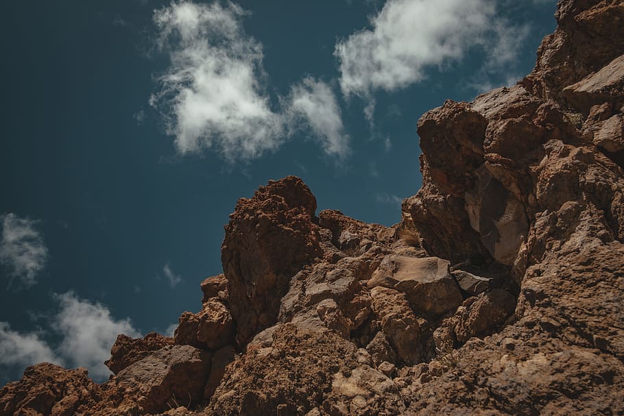 low-angle photography of rock formation under cloudy sky, mountain HD wallpaper