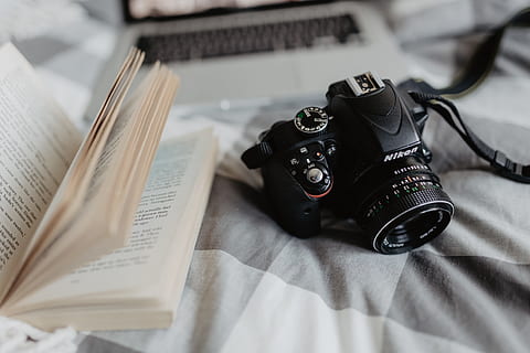 A camera, MacBook, and a book waiting in bed, room, computer HD wallpaper