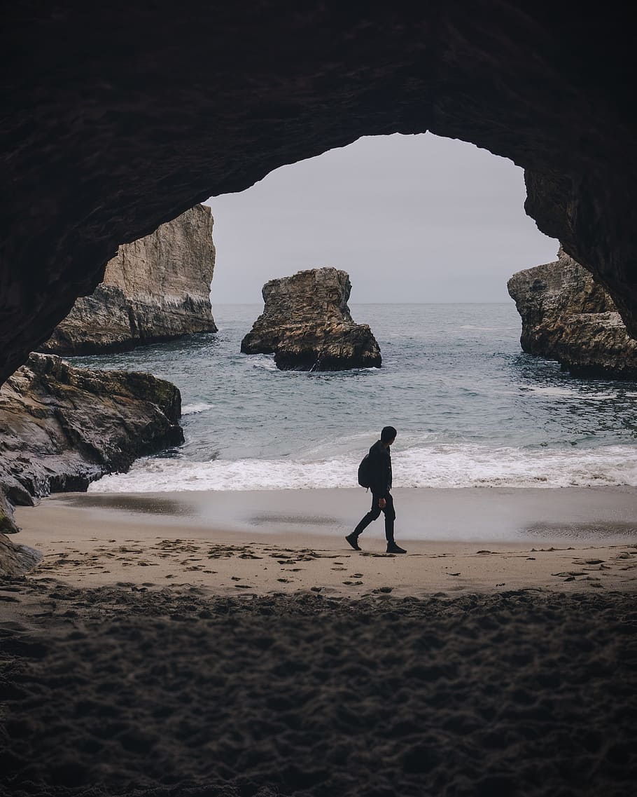 man walking beside shore, beach, cave, water, sea, tunnel, person HD wallpaper