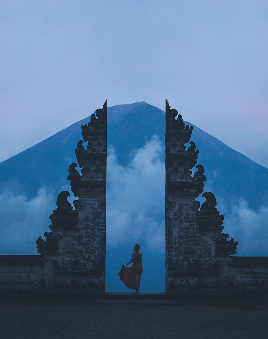 woman in between on concrete landmarks near white clouds, fog HD wallpaper