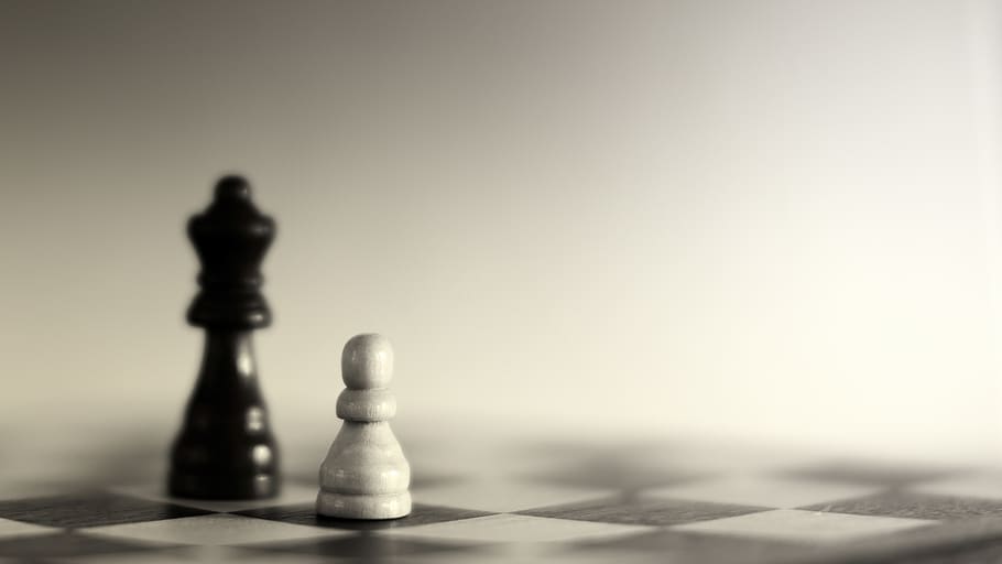 Premium Photo  Closeup of chess pieces on the chessboard under the lights  with a blurry background