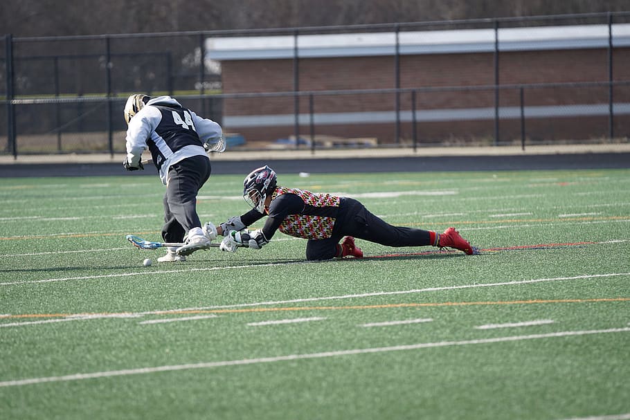 person playing lacrosse on field, human, clothing, apparel, helmet