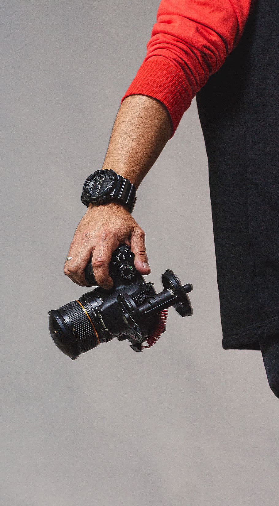 person holding black camera, human, electronics, wristwatch, finger