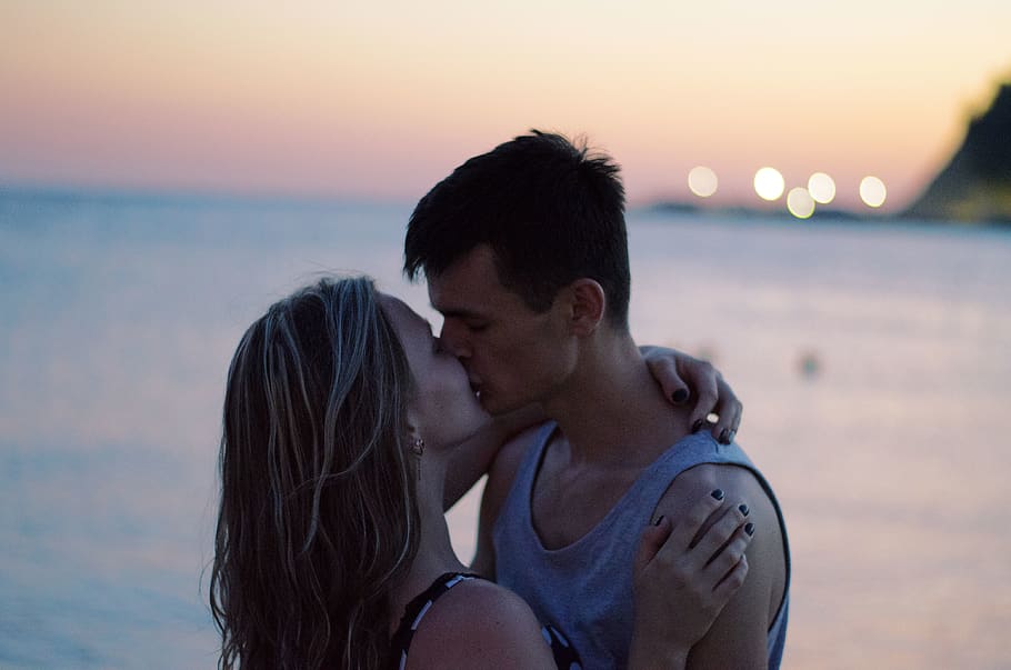 Selective Focus Photography of Couple Kissing on Shore, beach