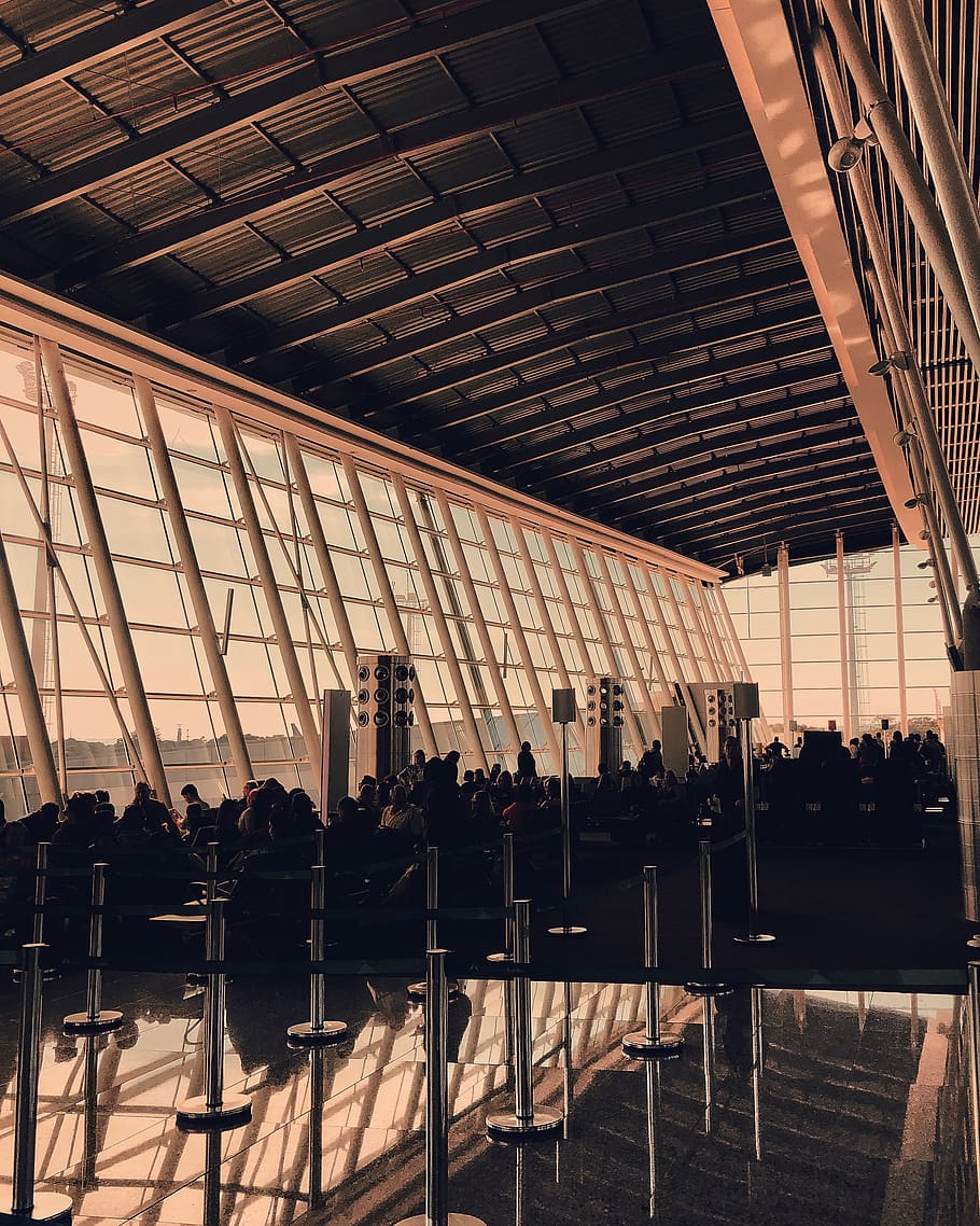 person sitting on chairs inside building, airport terminal, furniture