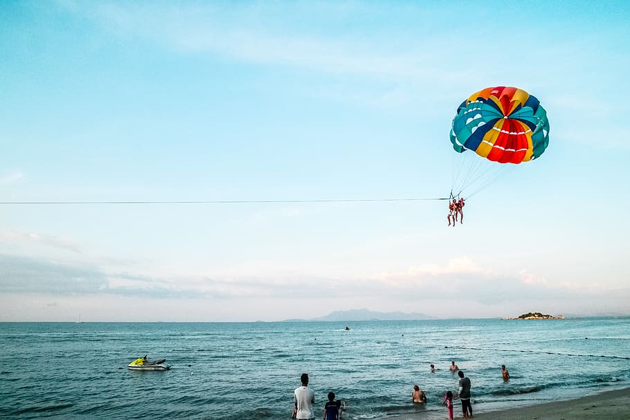 Person Riding Parachute Above Ocean, adventure, beach, coastline