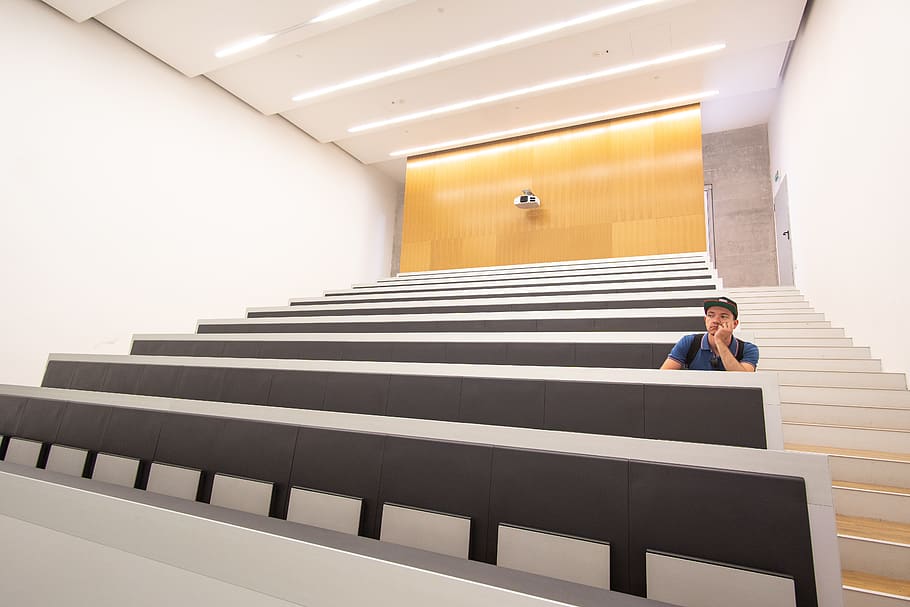 man sitting inside auditorium, architecture, one person, staircase HD wallpaper