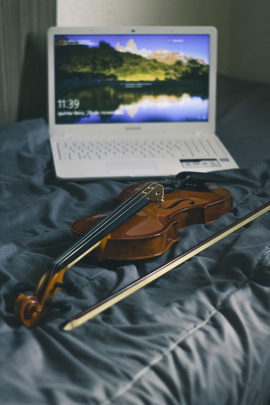 Photograph of White Laptop and Violin, bed, blur, bowed string instrument