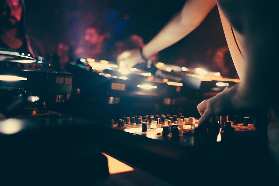 A DJ operating a music mixing console in a club, Bass, Control