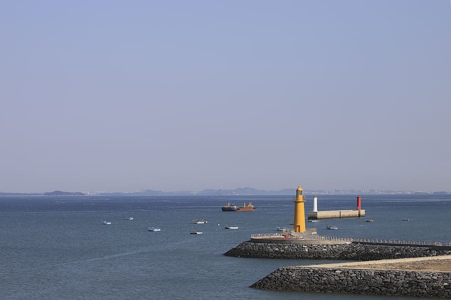 sea, lighthouse, coast, beach, scenery, yellow, water, sky HD wallpaper