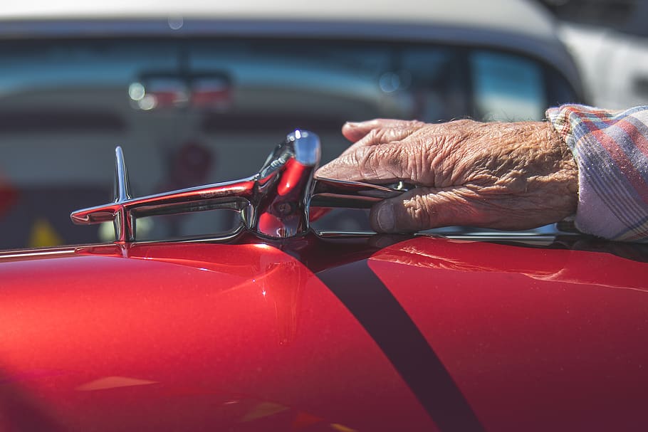 person touching chrome-colored emblem, mode of transportation HD wallpaper