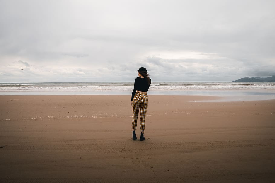 Woman Standing on Shoreline, back view, beach, breeze, cloudy HD wallpaper