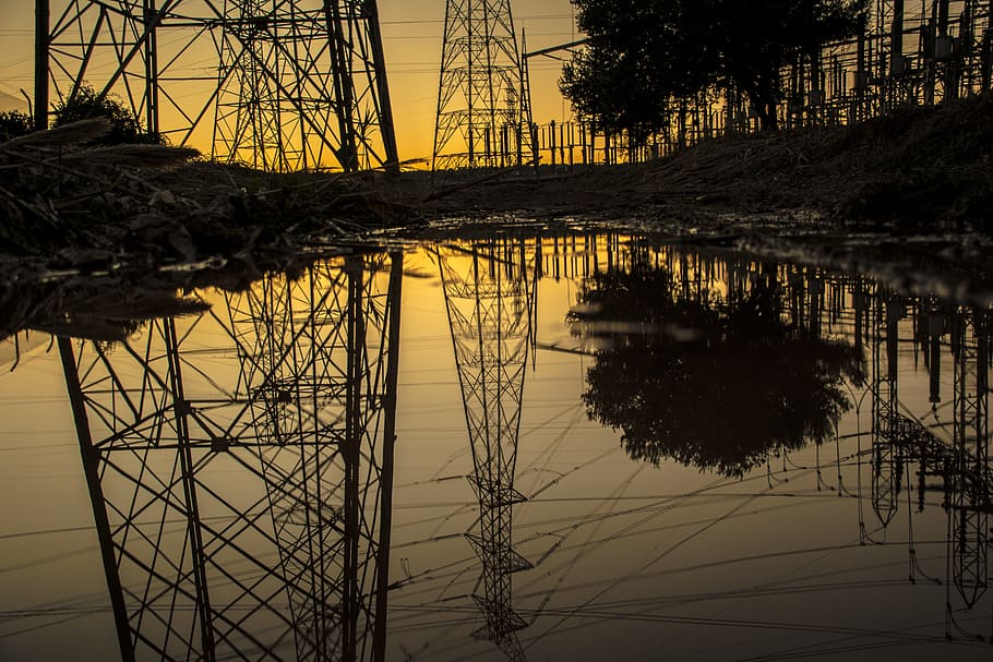 Silhouette of Trees and Electric Tower Reflecting on Body of Water during Sunset HD wallpaper