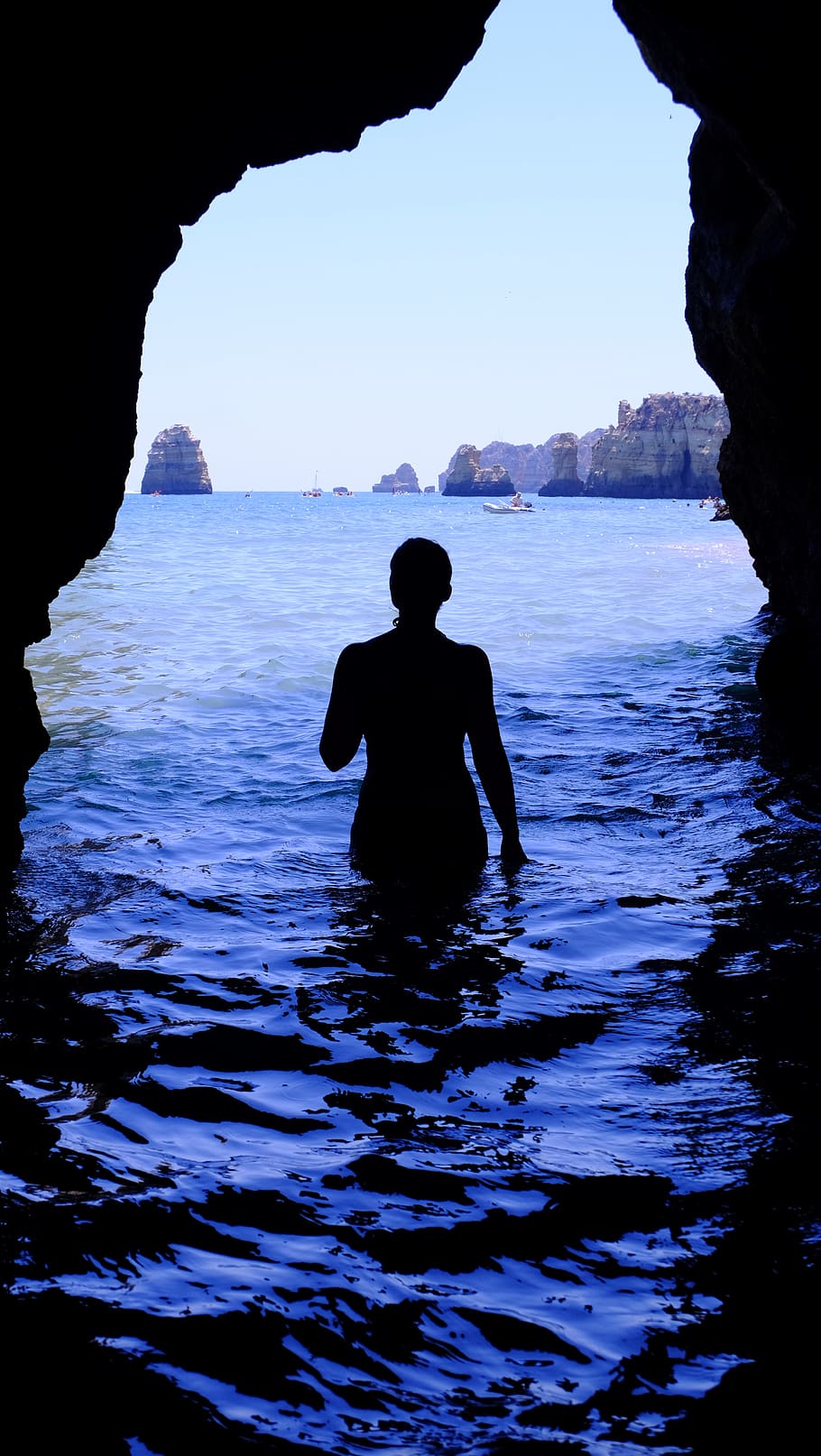 Silhouette of Woman at Blue Sea Inside Black Cave during Daytime HD wallpaper