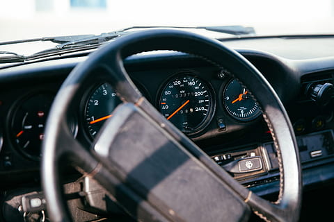 Side view of interior of a car with speedometer, dashborad and windshield in the background HD wallpaper