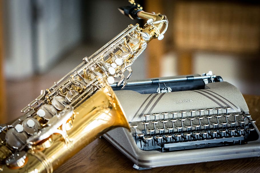 brass saxophone and typewriter on table, saxaphone, vintage, musical instrument