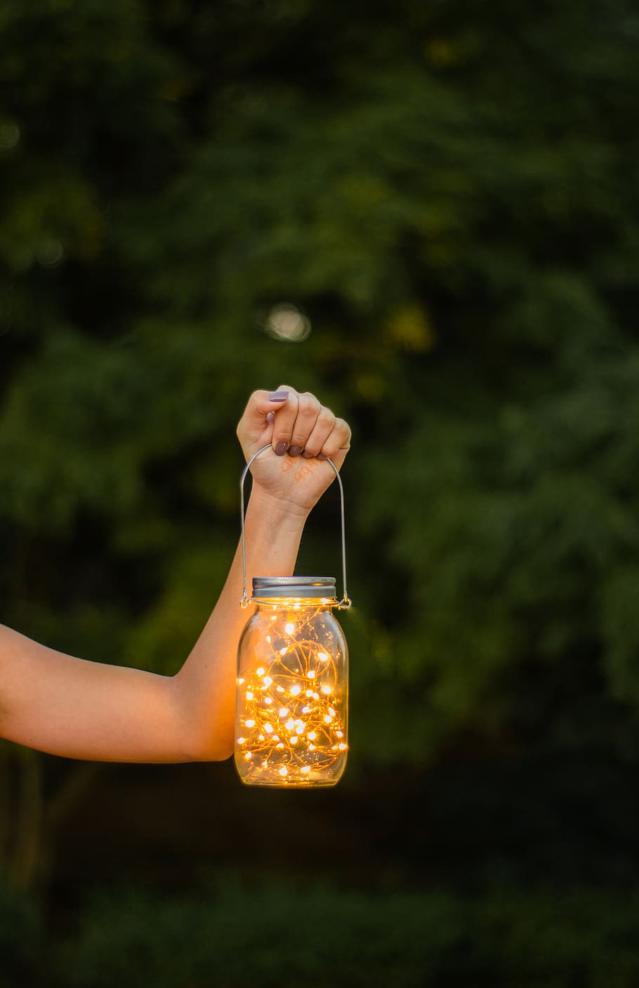 Photo of Woman's Hand Holding a Mason Jar with String Lights HD wallpaper